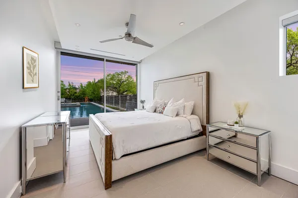 a view of a hallway with wooden floor and a bathroom