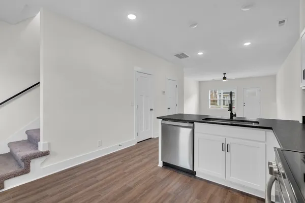 a kitchen with cabinets stainless steel appliances and a sink