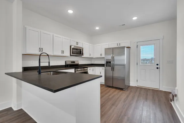 a kitchen with stainless steel appliances granite countertop a stove a sink and a microwave