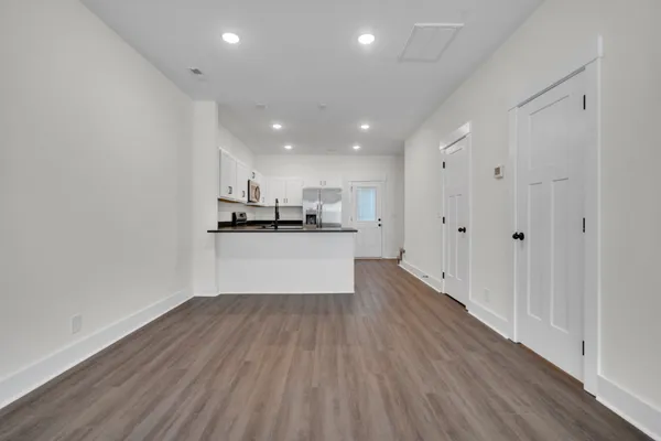 a view of empty room with wooden floor and ceiling fan