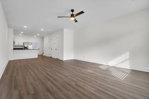 a view of a kitchen with wooden floor and a ceiling fan