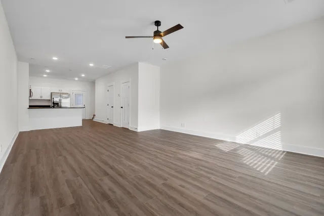 a view of a kitchen with wooden floor and a ceiling fan