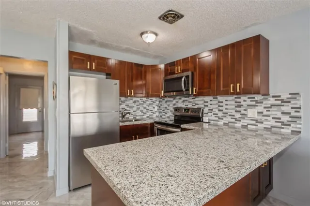 a kitchen with stainless steel appliances granite countertop a sink refrigerator and microwave