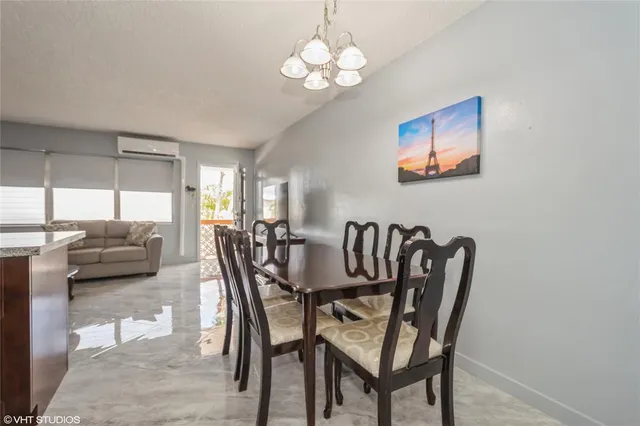 a view of a dining room with furniture a chandelier and a window