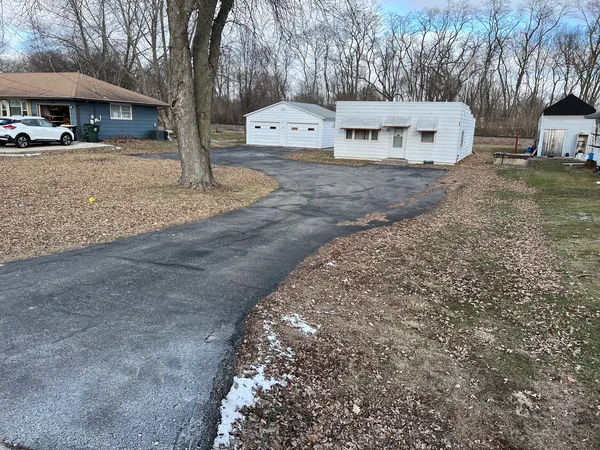 a view of a house with a yard and a large tree