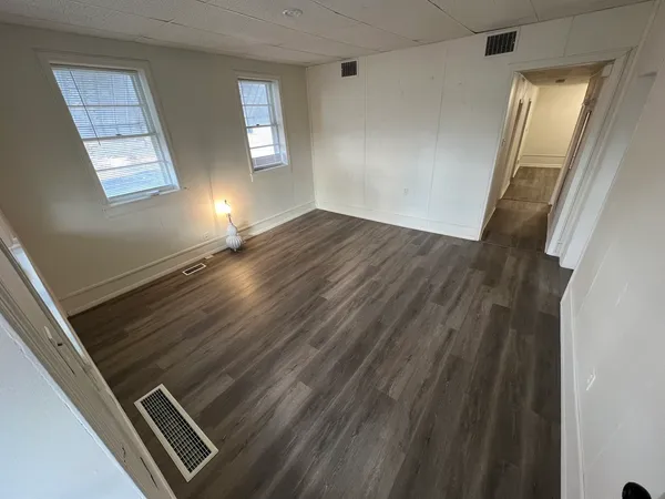 a view of an empty room and wooden floor
