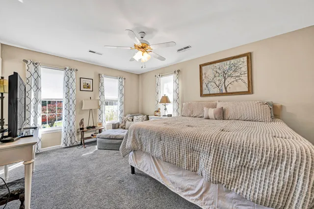 a bedroom with bed tv and a window