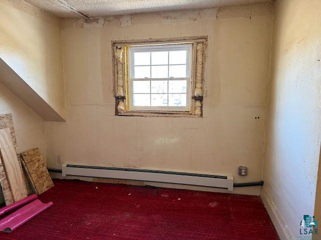 526 South 12th Street Virginia, MN 55792 - Photo 11 of 17 Spare room with dark colored carpet and a baseboard radiator