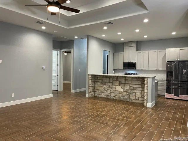 a view of kitchen with stainless steel appliances kitchen island granite countertop a stove a refrigerator and a sink