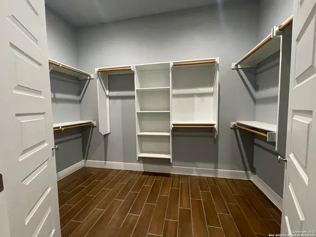 a view of walk in closet with empty racks