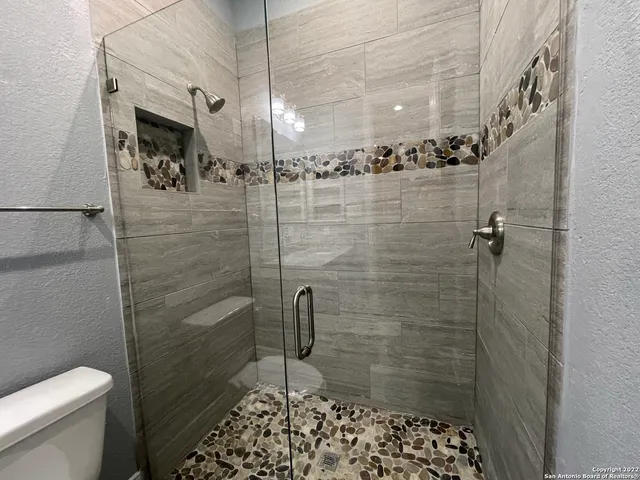 a bathroom with a shower a toilet and a sink