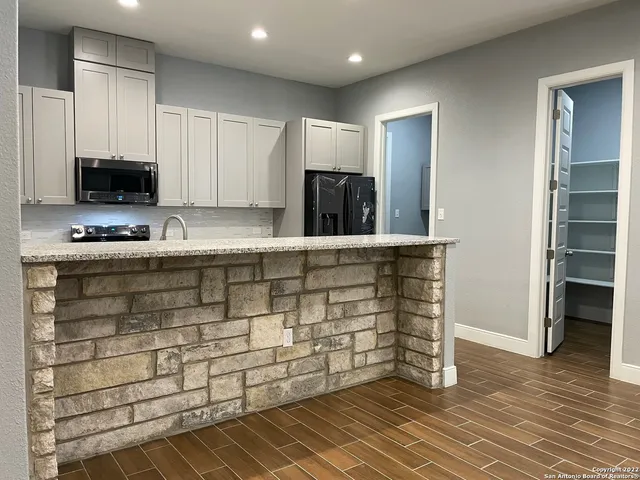 a kitchen with stainless steel appliances kitchen island granite countertop a stove and a sink
