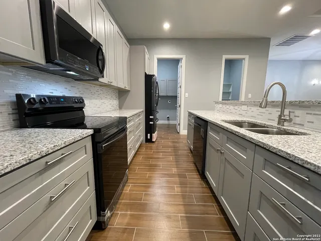 a kitchen with stainless steel appliances granite countertop a sink and a stove
