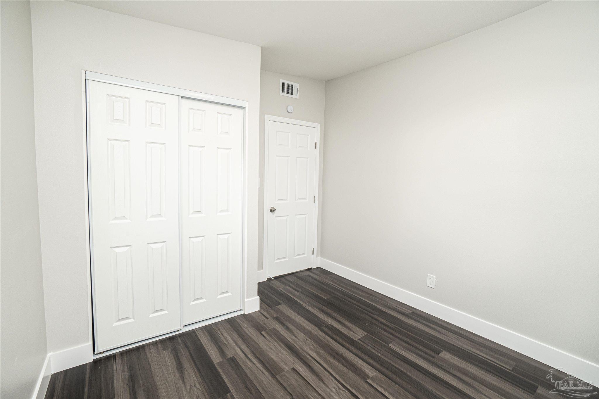 426 Forrest Street Cantonment, FL 32533 - Photo 14 of 25 a view of an empty room with wooden floor
