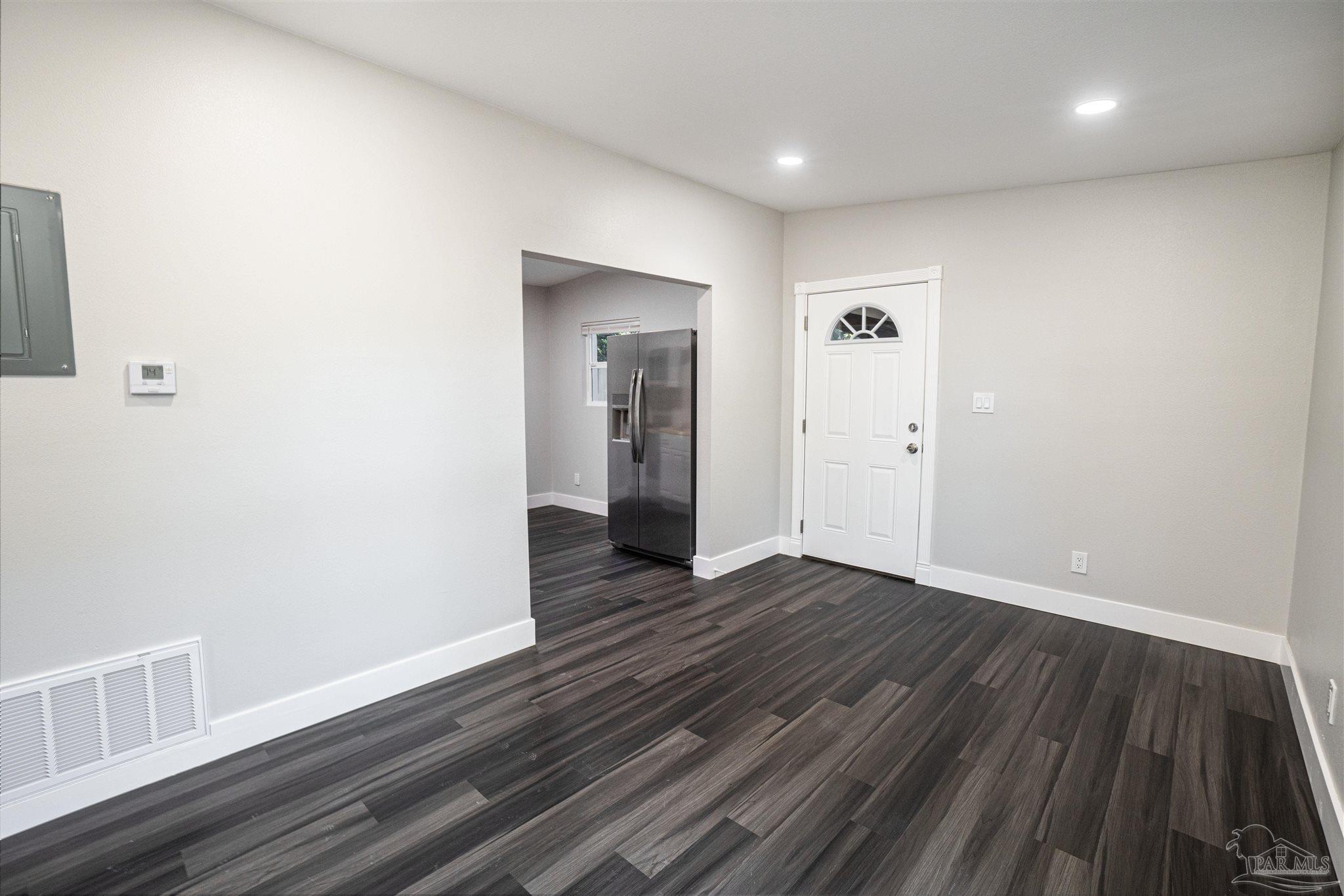 426 Forrest Street Cantonment, FL 32533 - Photo 2 of 25 a view of an empty room with wooden floor and a window