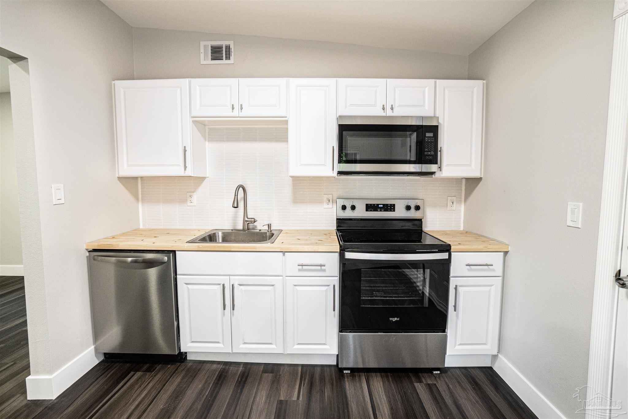 426 Forrest Street Cantonment, FL 32533 - Photo 5 of 25 a kitchen with a sink stove and microwave