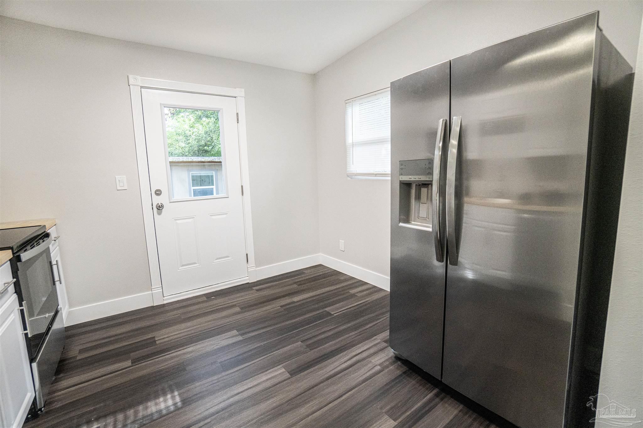 426 Forrest Street Cantonment, FL 32533 - Photo 6 of 25 a kitchen with a refrigerator and wooden floor