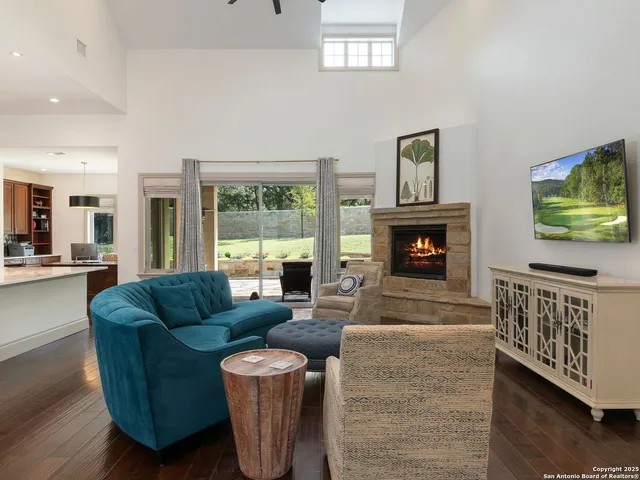 a living room with furniture a flat screen tv and a fireplace