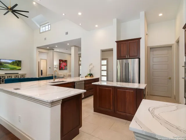 a kitchen with stainless steel appliances granite countertop a sink and a refrigerator