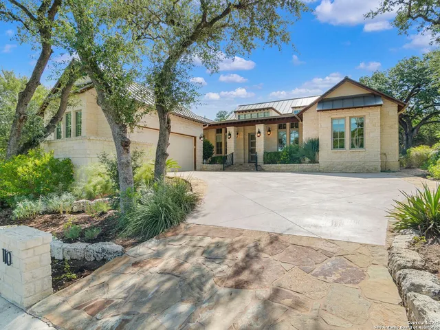 a front view of a house with a yard and potted plants