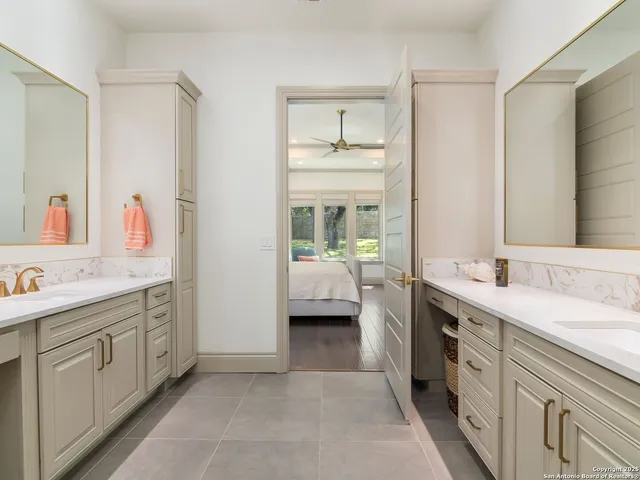 a en suite bathroom with 2 sink tub and a mirror