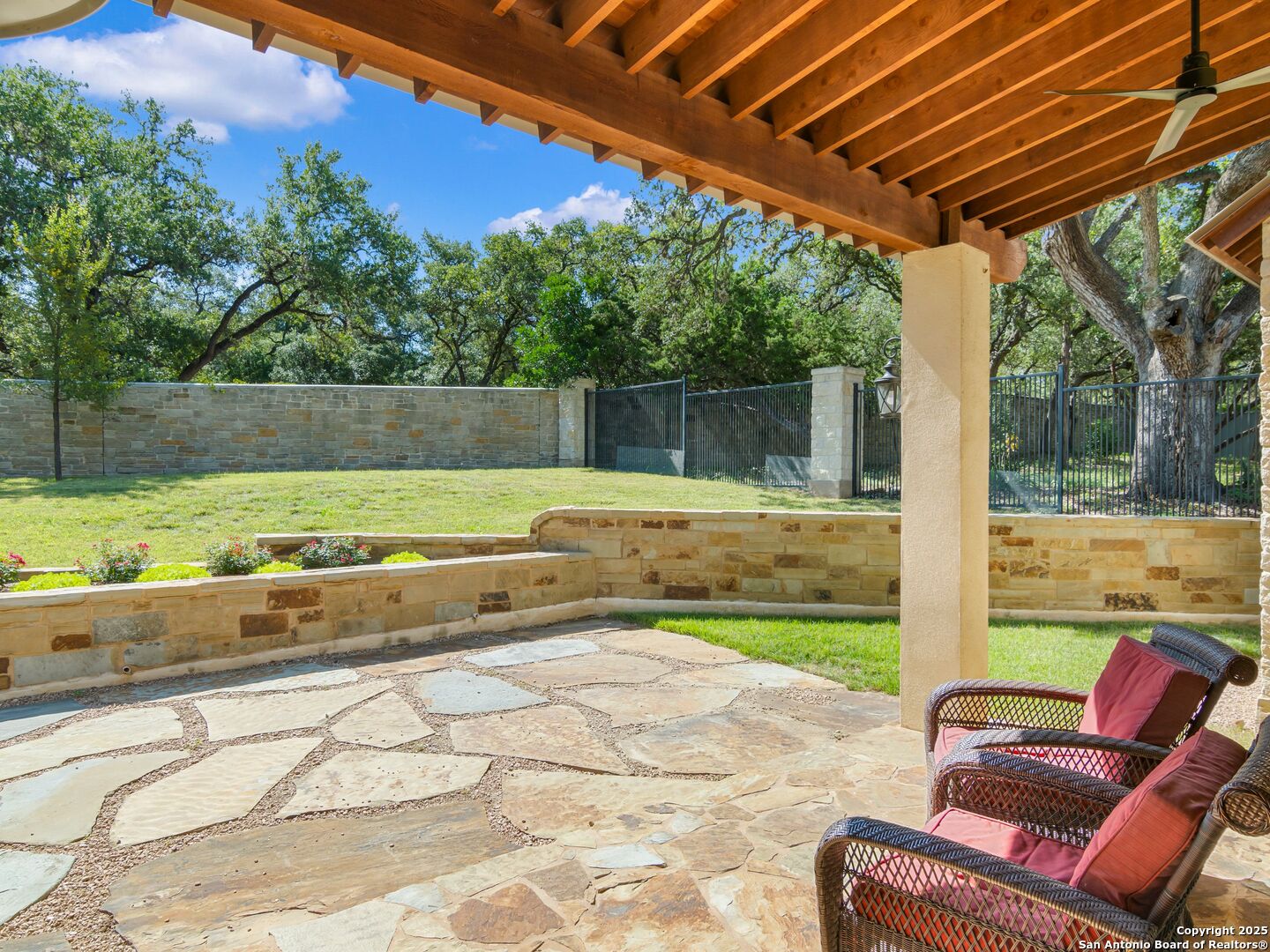 110 Manorbrook San Antonio, TX 78230 - Photo 27 of 40 a view of a backyard with lawn chairs under an umbrella