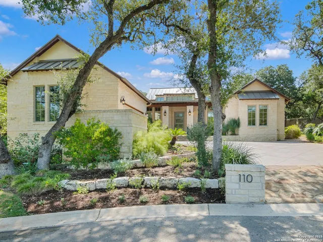 a view of a white house with a yard and potted plants