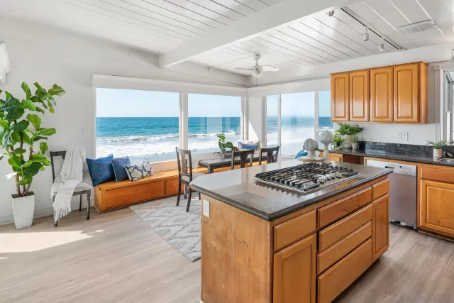 a kitchen with a stove a sink and a wooden cabinets