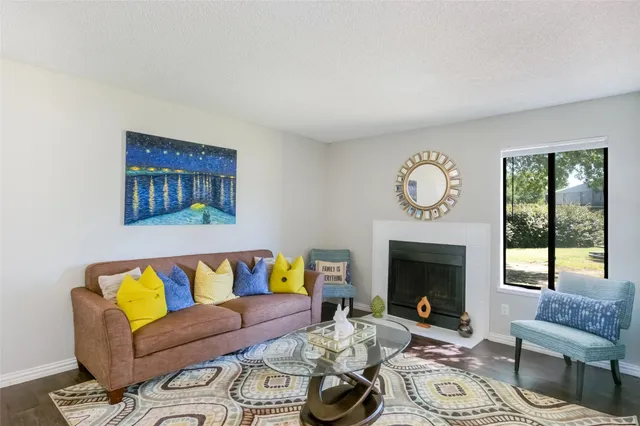 a living room with furniture a fireplace and a large window