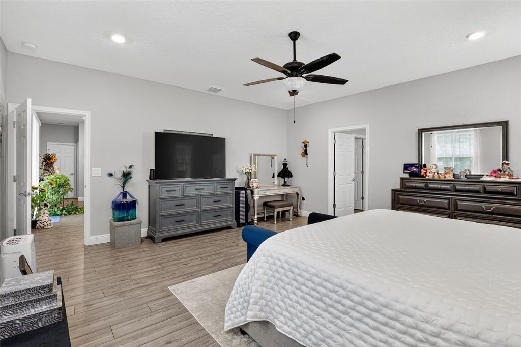 9839 Southwest 40th Terrace Ocala, FL 34476 - Photo 11 of 16 a bedroom with a bed and flat screen tv