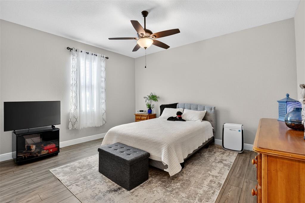 9839 Southwest 40th Terrace Ocala, FL 34476 - Photo 12 of 16 a bedroom with a bed a fireplace and a flat screen tv