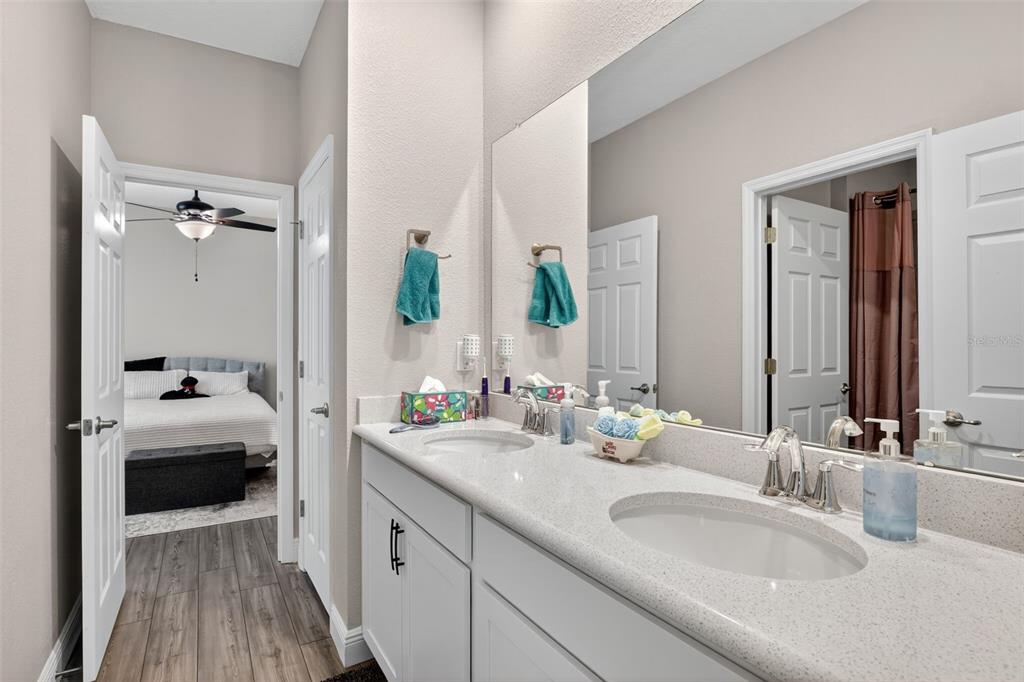 9839 Southwest 40th Terrace Ocala, FL 34476 - Photo 15 of 16 a en suite bathroom with a double vanity sink and mirror