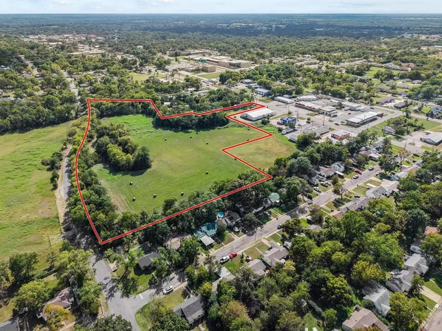 an aerial view of residential houses with outdoor space and trees