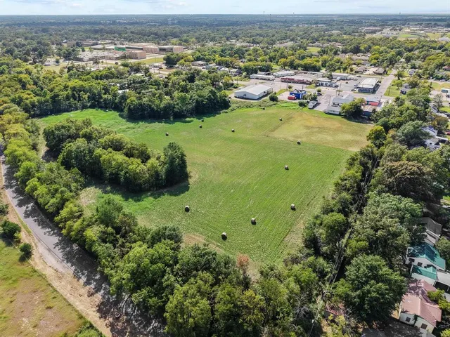 an aerial view of residential houses with outdoor space and trees