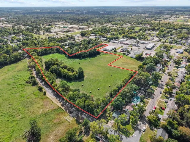 an aerial view of residential houses with outdoor space and trees