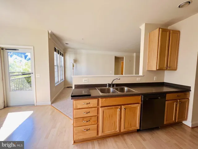 a kitchen with granite countertop a sink and a wooden cabinets