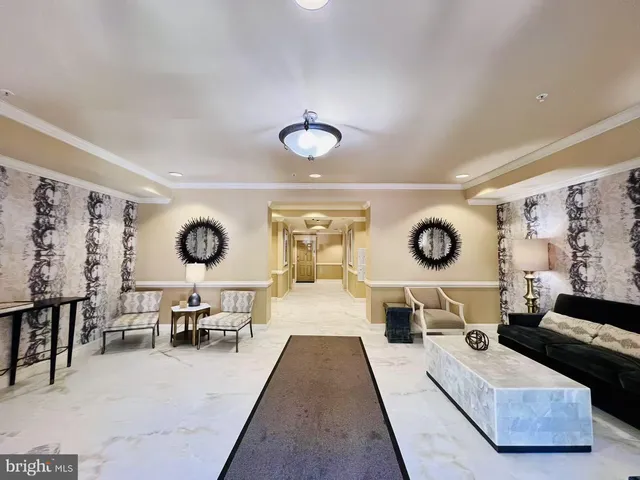 a living room with furniture and a clock on dresser next to a window