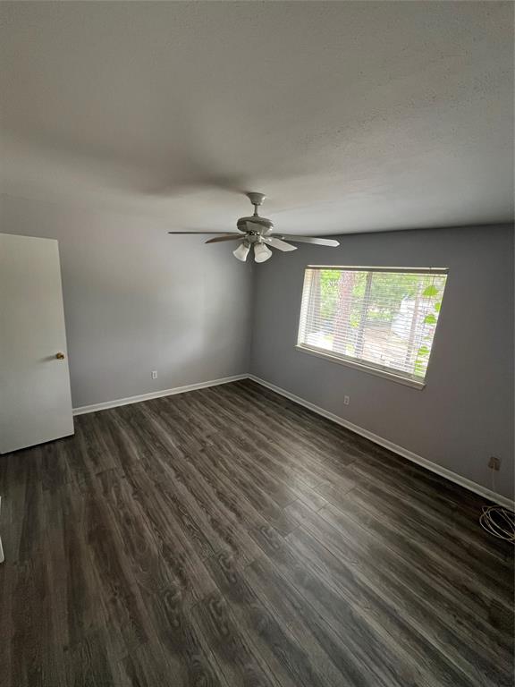 7000 Creswell Road, Unit 223 Shreveport, LA 71106 - Photo 12 of 16 Empty room with a ceiling fan, dark wood-style floors, and baseboards