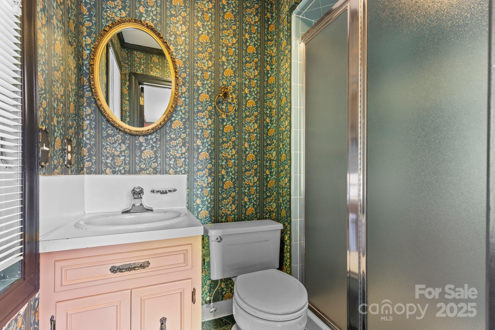 1653 Dudley Shoals Road Granite Falls, NC 28630 - Photo 28 of 48 a bathroom with a toilet sink vanity and mirror