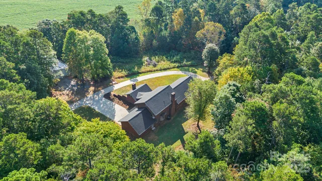an aerial view of a house with a yard swimming pool and lake view