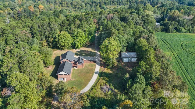 an aerial view of a house with a yard and trees