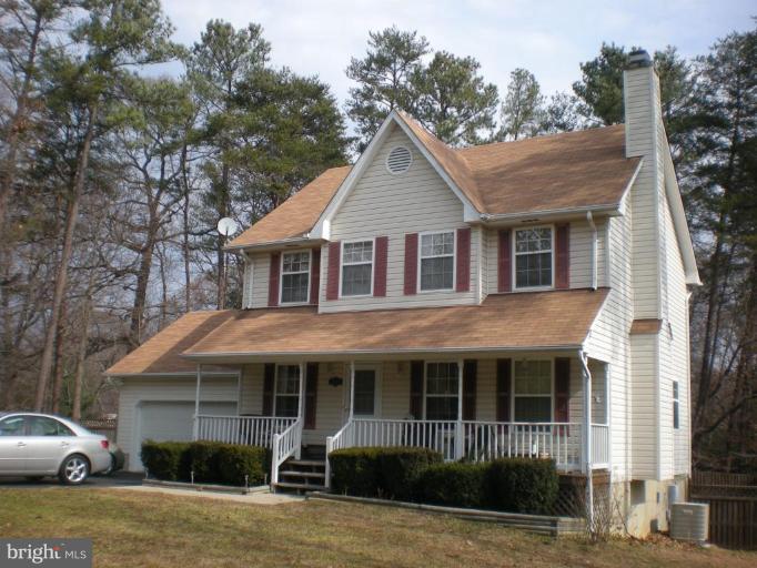 5906 Hillside Road St. Leonard, MD 20685 - Photo 1 of 1 a front view of a house with a yard and potted plants