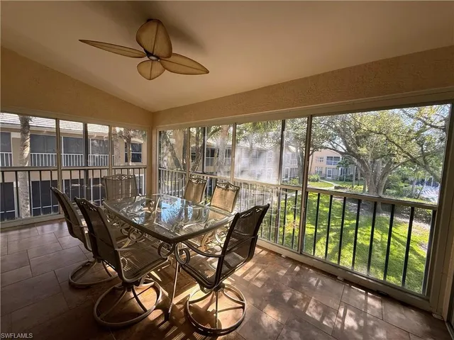 a dining room with furniture water view and a floor to ceiling window
