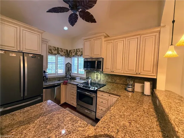 a kitchen with stainless steel appliances granite countertop a stove refrigerator and microwave