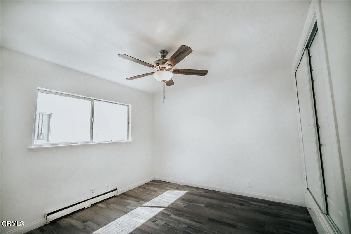 1361 Edgewood Way, Unit 61 Oxnard, CA 93030 - Photo 14 of 22 a view of a room with wooden floor and a ceiling fan