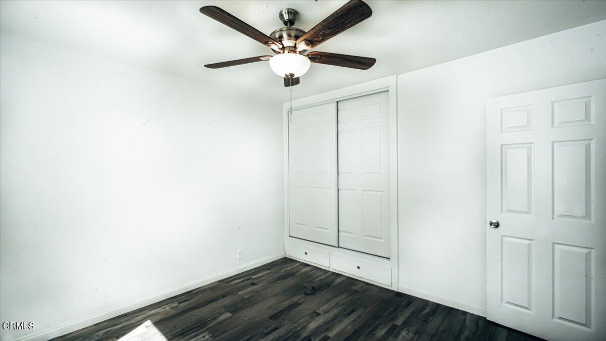 1361 Edgewood Way, Unit 61 Oxnard, CA 93030 - Photo 15 of 22 an empty room with wooden floor and ceiling fan