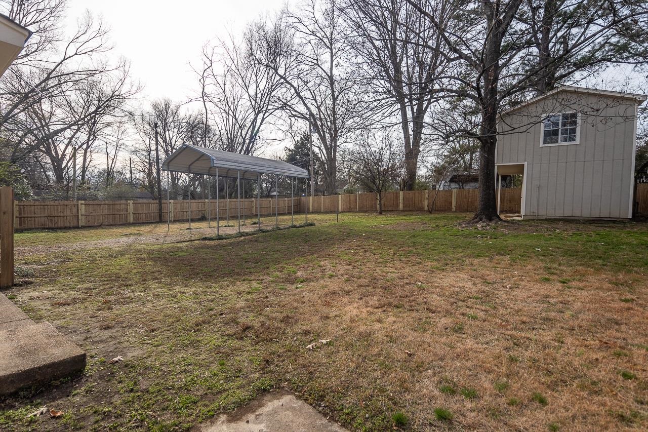 627 Watson Street Memphis, TN 38111 - Photo 24 of 35 a view of a yard with a house and trees in the background