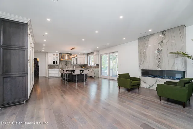 a view of a patio with couches table and chairs under an umbrella