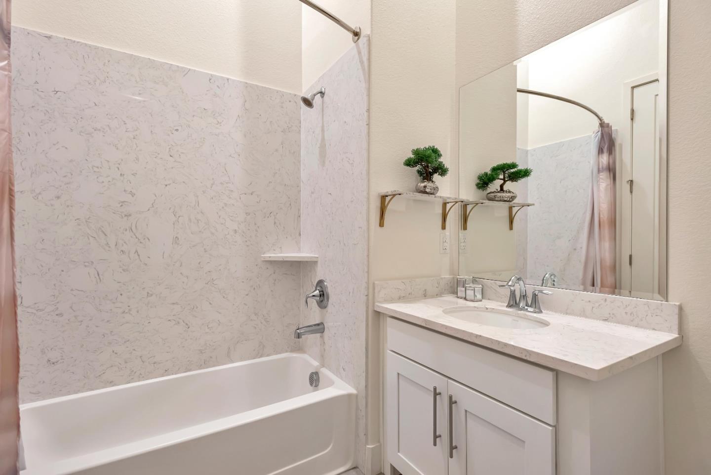 1038 Foster Square Lane, Unit 403 Foster City, CA 94404 - Photo 16 of 28 a bathroom with a bathtub sink and mirror
