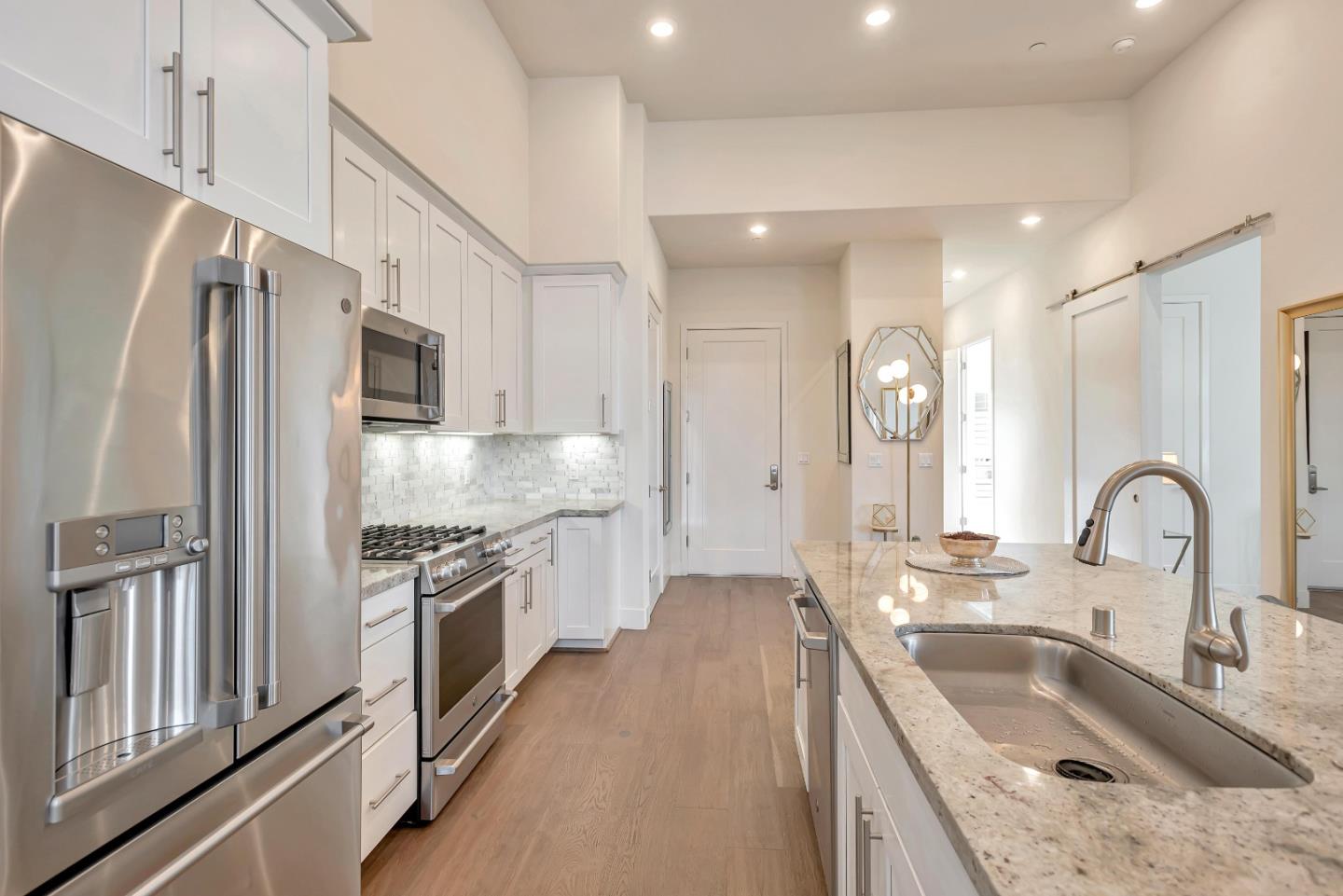 1038 Foster Square Lane, Unit 403 Foster City, CA 94404 - Photo 6 of 28 a kitchen with stainless steel appliances granite countertop a sink stove and refrigerator